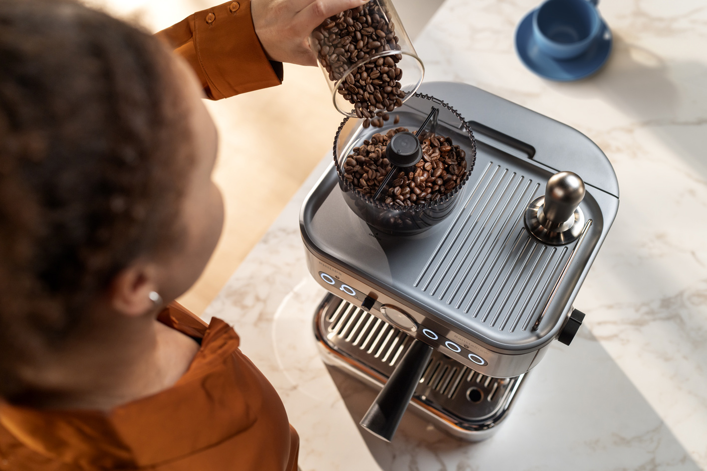 Noor naine valab kohviube Philips Barista Brew kohviubade mahutisse